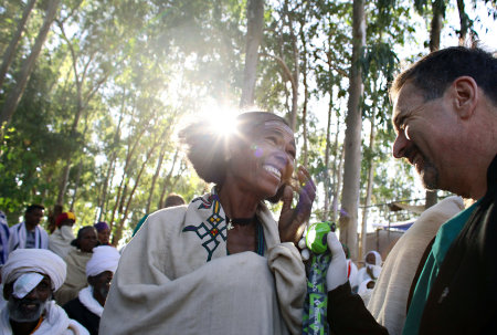 Dr. Tabin checks the eyes of an ecstatic woman who can see again after her cataract surgery.